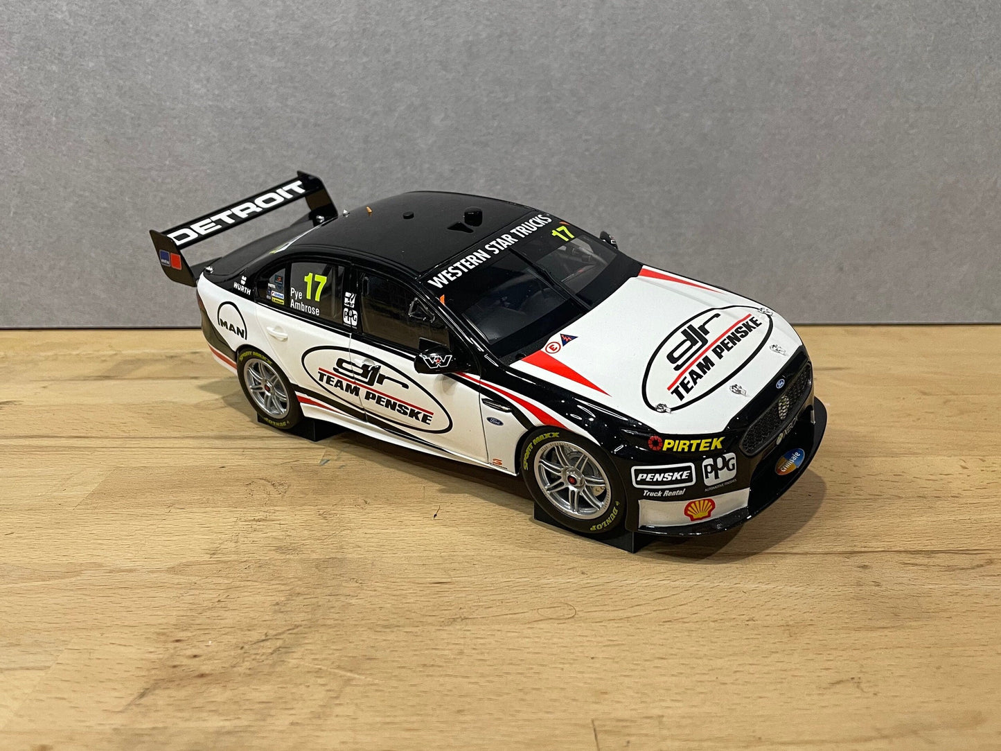 1:18 scale DJR Team Penske Ford Falcon V8 Supercar diecast model displayed on a wooden surface, featuring livery for driver #17 and sponsor detailing.