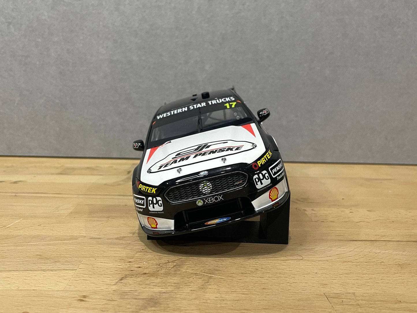 1:18 scale DJR Team Penske Ford Falcon V8 Supercar diecast model displayed on a wooden surface, featuring livery for driver #17 and sponsor detailing.
