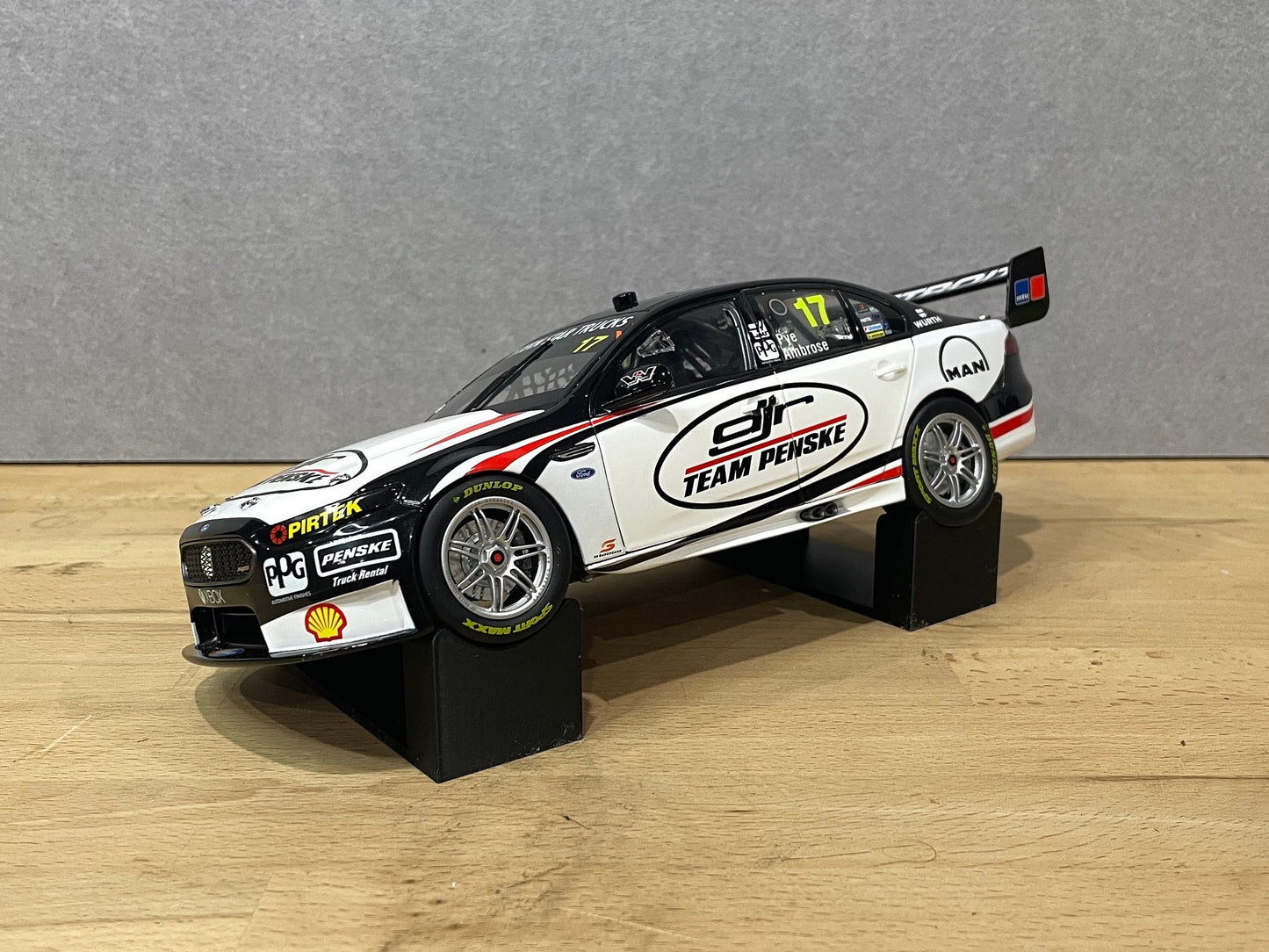 1:18 scale DJR Team Penske Ford Falcon V8 Supercar diecast model displayed on a wooden surface, featuring livery for driver #17 and sponsor detailing.